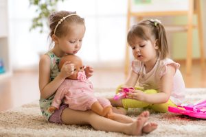 children playing doctor with doll indoor